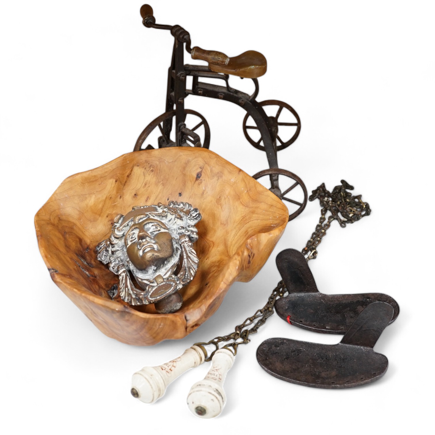 A cast iron toy model of a tricycle, a carved wooden bow, a classical figurative door knocker, a pair of metal cow shoes and two ceramic cistern pulls, bowl 30cm diameter. Condition - fair